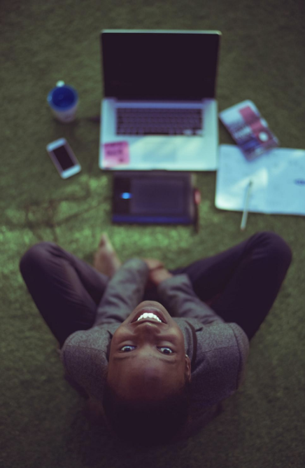 decorative image of a student on a laptop looking up at the camera.